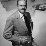 Raymond Loewy sitting with a cigarette in hand