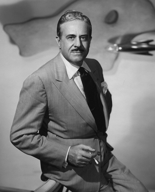 Raymond Loewy sitting with a cigarette in hand